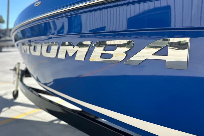 Slide: The Image of 2015 Moomba Mobius LSV boat with blue and gray seating, sunny day. - 13