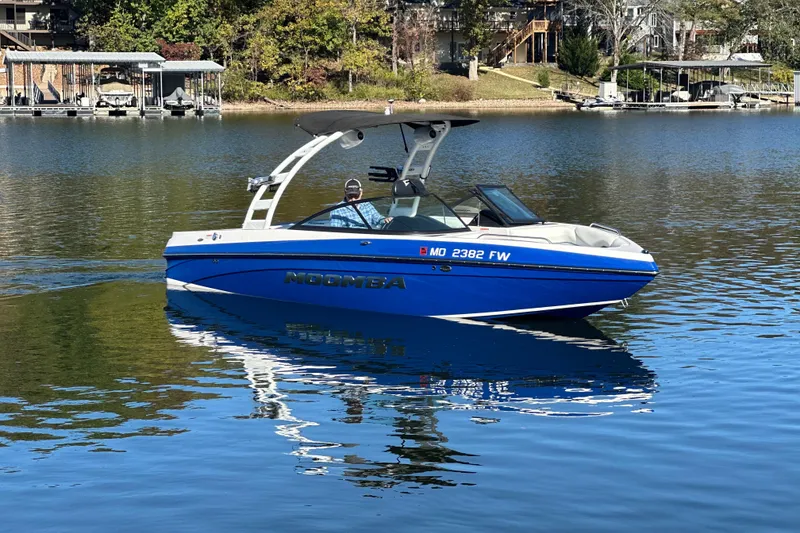 Slide: The Image of 2015 Moomba Mobius LSV boat cruising on a calm lake with scenic background. - 54