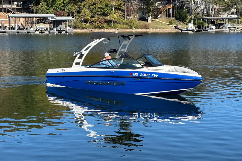 Slide: The Image of 2015 Moomba Mobius LSV boat on a calm lake, reflecting in the water. - 55