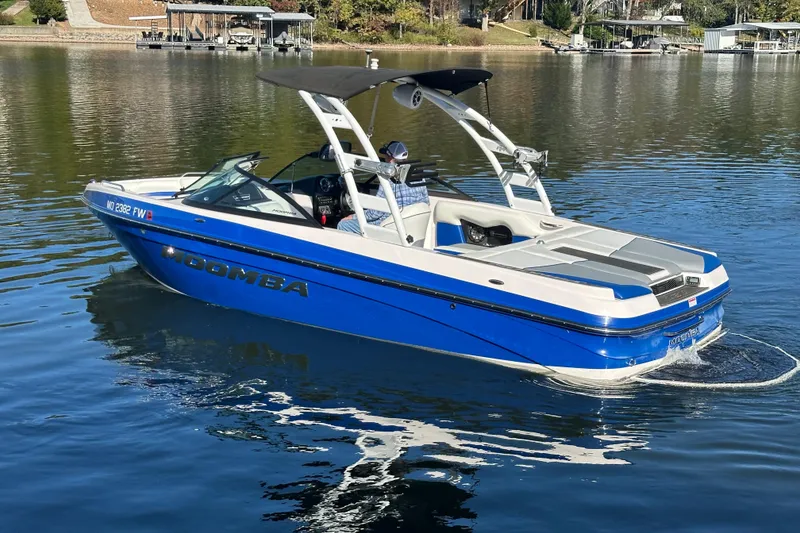 Slide: The Image of 2015 Moomba Mobius LSV boat in blue, cruising on a calm lake. - 67