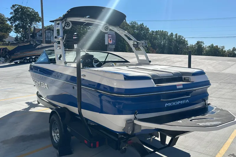Slide: The Image of 2015 Moomba Mobius LSV boat on trailer in parking lot under clear blue sky. - 7