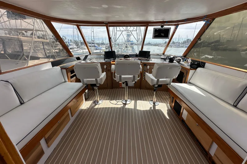 Slide: The Image of 1973 Elliott Yachtfisher docked at marina, featuring spacious deck and ladder access. - 12