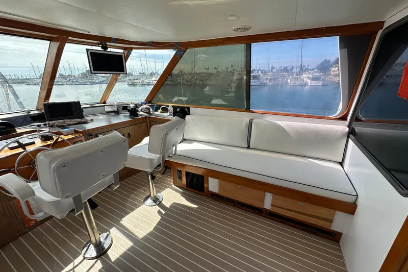Slide: The Image of Interior of a 1973 Elliott Yachtfisher, featuring helm controls and marina view. - 15