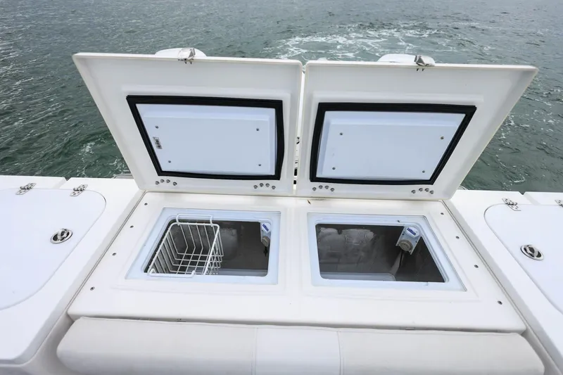 Slide: The Image of Open storage compartments on 2022 Sea Fox 368 Commander boat, with ocean in background. - 10