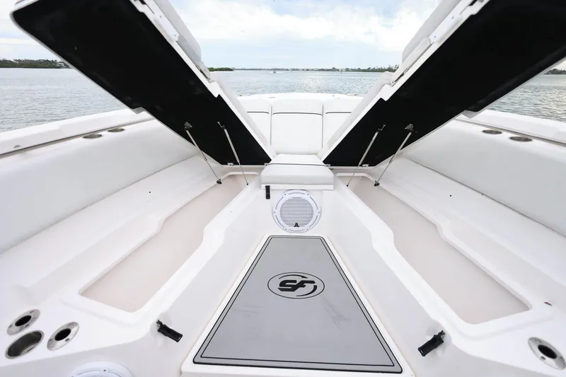 Slide: The Image of 2022 Sea Fox 368 Commander boat interior with open storage compartments, on calm water. - 30