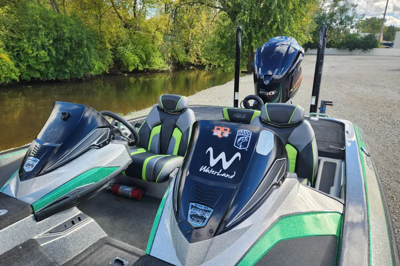 Slide: The Image of 2019 Skeeter FX21 boat with custom seats and decals, parked by a river. - 13