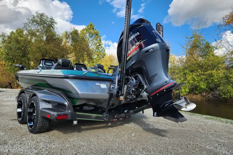 Slide: The Image of 2019 Skeeter FX21 boat with Yamaha engine, parked near a river under a blue sky. - 7