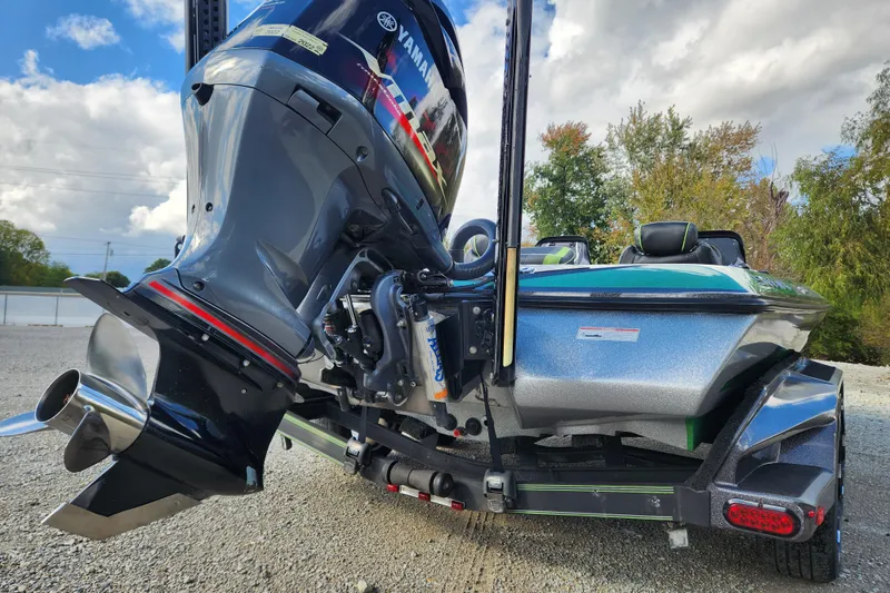 Slide: The Image of 2019 Skeeter FX21 boat with Yamaha outboard motor, parked on gravel, under cloudy sky. - 8