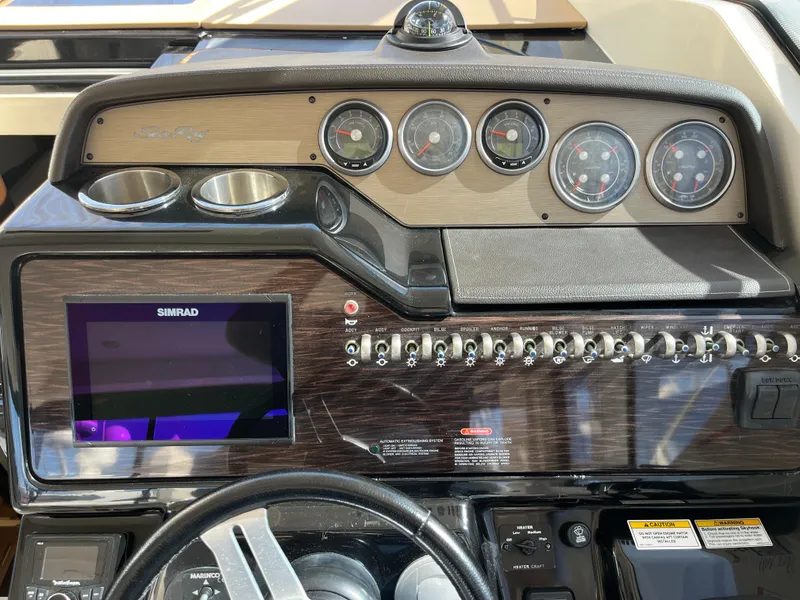 Slide: The Image of 2018 Sea Ray Sundancer 350 dashboard with gauges, controls, and Simrad display. - 23