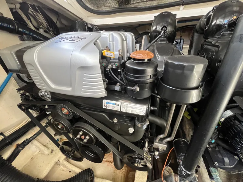 Slide: The Image of Engine compartment of a 2018 Sea Ray Sundancer 350 boat, showcasing detailed mechanical components. - 28