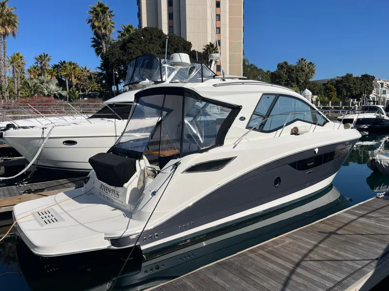 Slide: The Image of 2018 Sea Ray Sundancer 350 yacht docked at marina, clear sky, palm trees in background. - 3