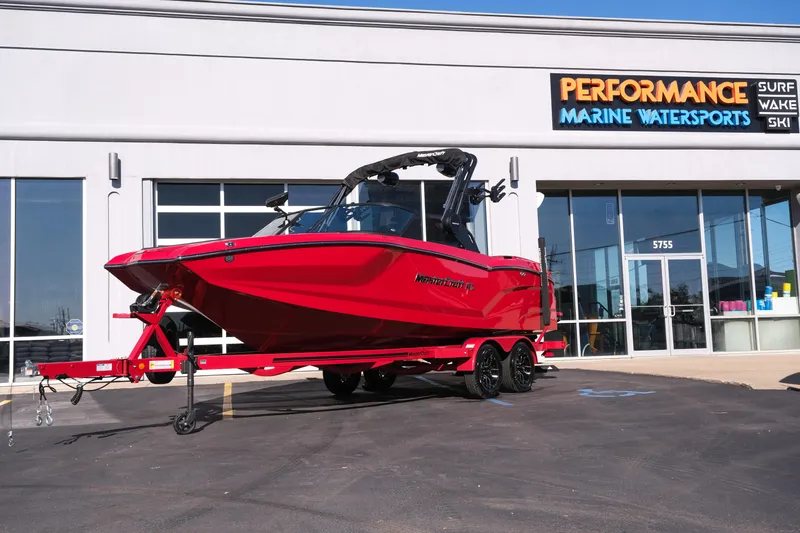 The Image of 2026 MasterCraft NXT22 boat in vibrant red outside Performance Marine Watersports store. - 1
