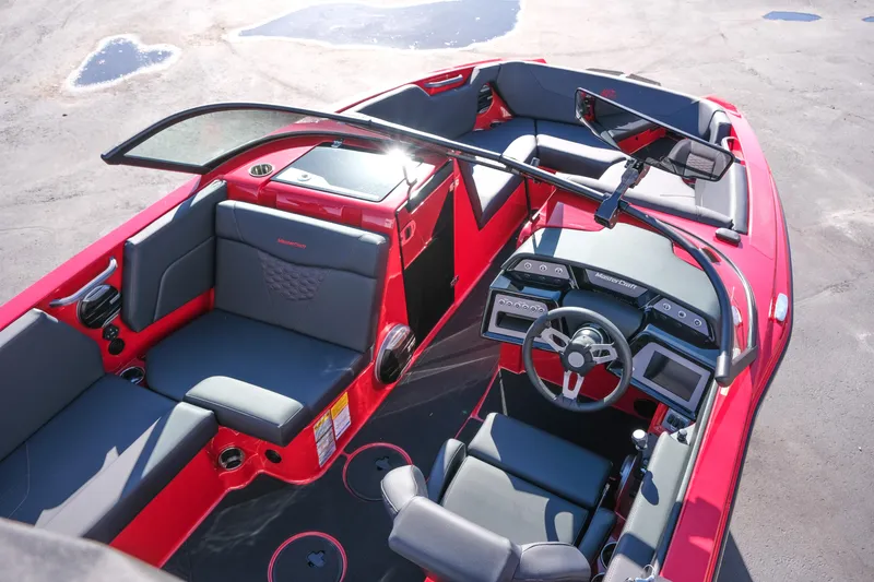 Slide: The Image of 2026 MasterCraft NXT22 boat interior with red and gray seating, modern dashboard, and steering wheel. - 10