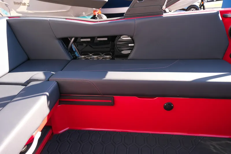 Slide: The Image of 2026 MasterCraft NXT22 interior with gray seating, cup holders, and red accents. - 13