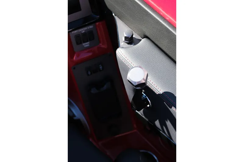 Slide: The Image of Interior detail of 2026 MasterCraft NXT22 boat, featuring control knobs and red accents. - 19