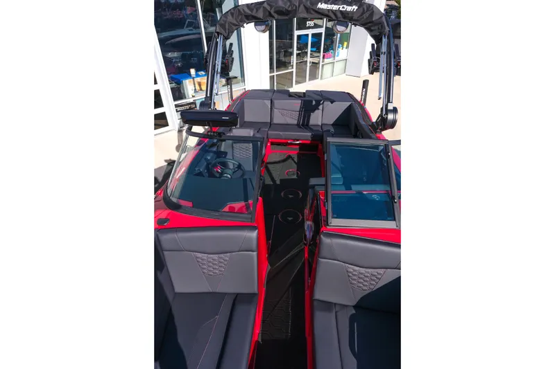 Slide: The Image of 2026 MasterCraft NXT22 boat interior with red and gray seating, open windshield, and tower. - 22