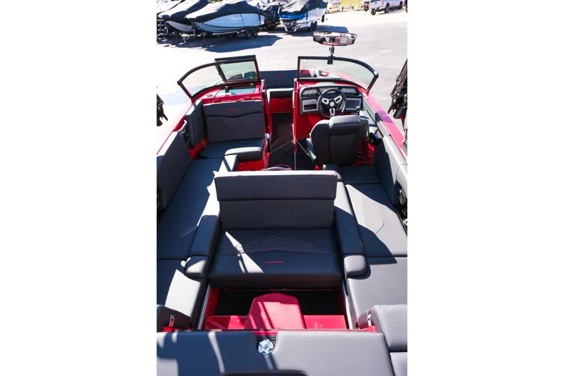 Slide: The Image of 2026 MasterCraft NXT22 boat interior with red and gray seating, modern dashboard, and open layout. - 24