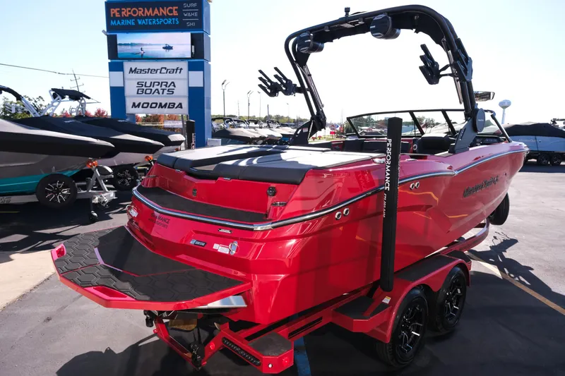 Slide: The Image of 2026 MasterCraft NXT22 boat in vibrant red at a marine dealership. - 7