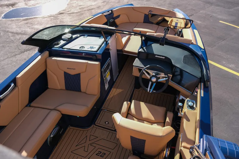 Slide: The Image of 2026 MasterCraft XT22 boat interior with tan and blue seating, sleek dashboard, and modern design. - 10
