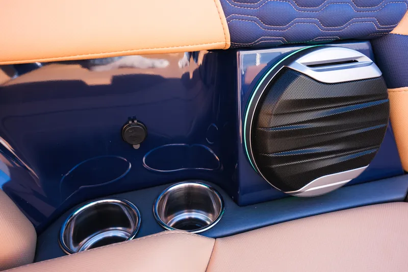 Slide: The Image of 2026 MasterCraft XT22 interior with speaker and cup holders, featuring blue and tan upholstery. - 22