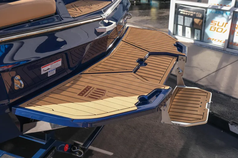 Slide: The Image of 2026 MasterCraft XT22 boat with teak swim platform and step, displayed outdoors. - 7