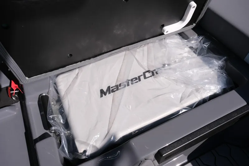 Slide: The Image of 2026 MasterCraft NXT20 boat storage compartment with branded cover in protective plastic. - 15
