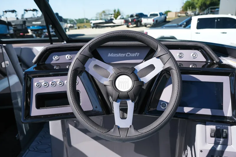 Slide: The Image of Steering wheel and dashboard of 2026 MasterCraft NXT20 boat, featuring modern controls and displays. - 16