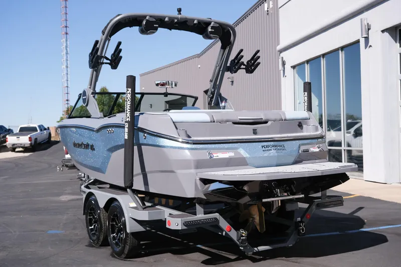 Slide: The Image of 2026 MasterCraft NXT20 boat on trailer, parked outside a building. - 4