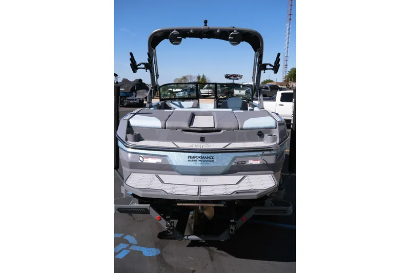 Slide: The Image of 2026 MasterCraft NXT20 boat, rear view, parked outdoors on a sunny day. - 6