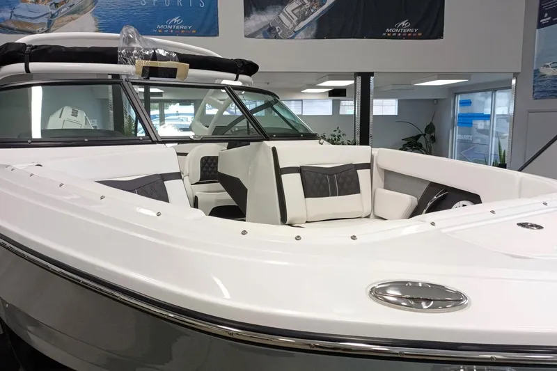 Slide: The Image of 2025 Monterey M-225 boat interior with sleek white and gray seating in showroom. - 3