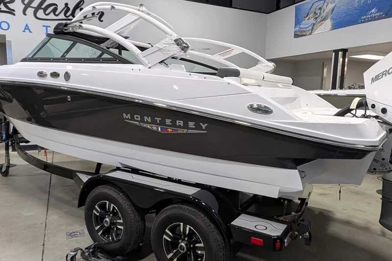 Slide: The Image of 2025 Monterey M-205 boat on trailer in showroom, featuring sleek design and modern features. - 2