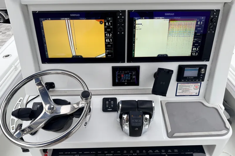 Slide: The Image of 2022 Costa Custom Boats 264 helm with dual Simrad displays and modern controls. - 12
