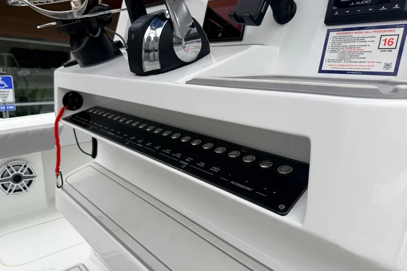 Slide: The Image of Control panel of 2022 Costa Custom Boats 264 with switches and emergency radio call procedures. - 13