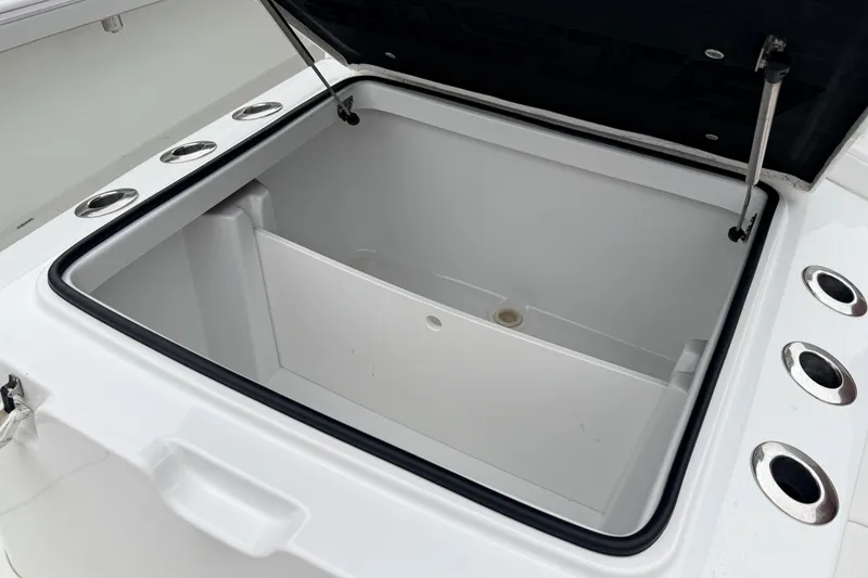 Slide: The Image of Open storage compartment on 2022 Costa Custom Boats 264, featuring multiple cup holders. - 18