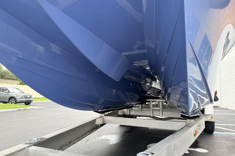 Slide: The Image of 2022 Costa Custom Boats 264 hull on trailer, showcasing sleek blue design. - 26