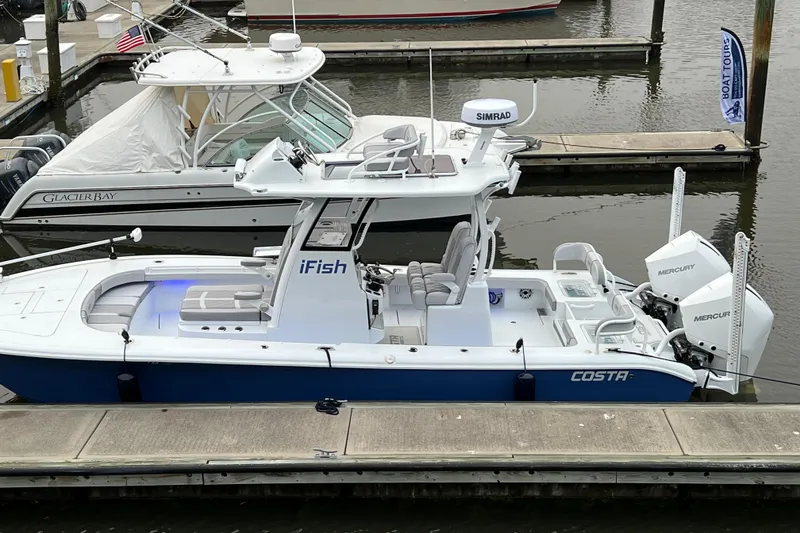 Slide: The Image of 2022 Costa Custom Boats 264 docked, featuring dual Mercury engines and sleek design. - 29