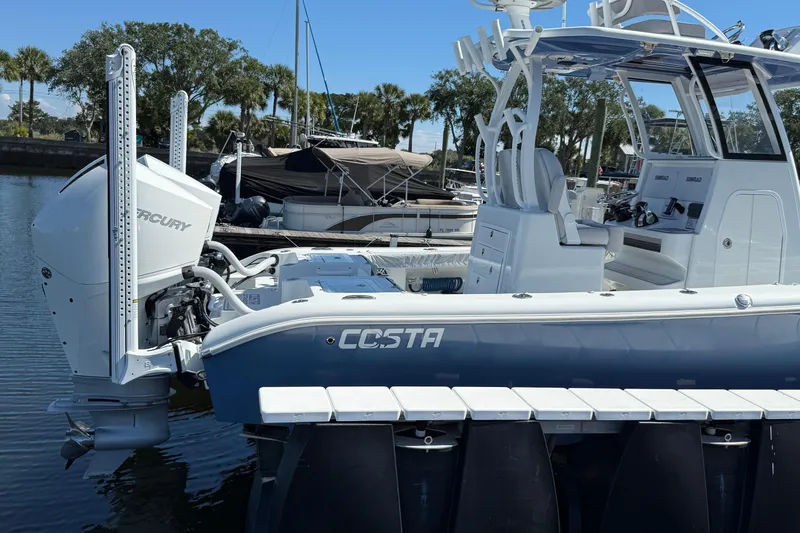 Slide: The Image of 2022 Costa Custom Boats 264 docked, featuring Mercury outboard engine, sleek design, and modern amenities. - 31