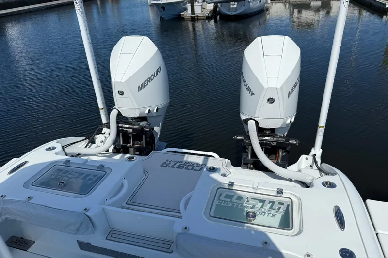 Slide: The Image of 2022 Costa Custom Boats 264 with twin Mercury engines at a marina. - 32
