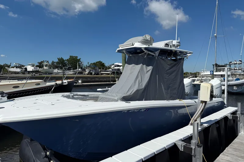 Slide: The Image of 2022 Costa Custom Boats 264 docked, covered, under a clear blue sky. - 35