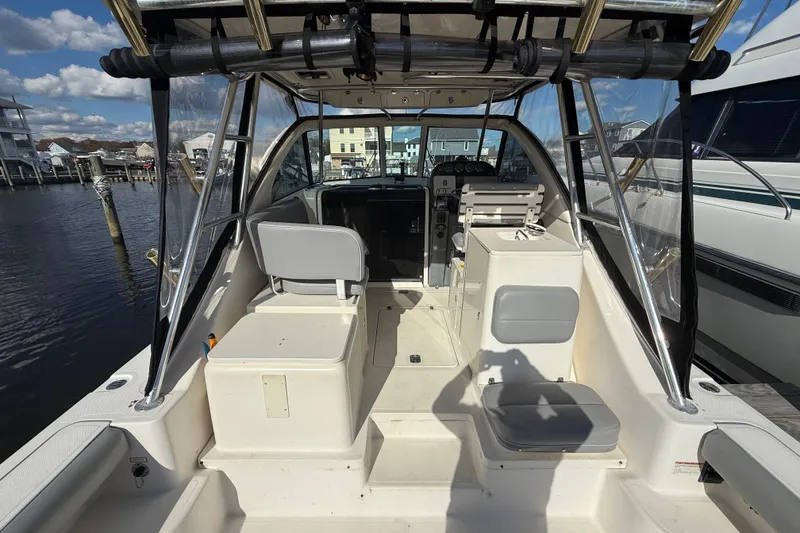 Slide: The Image of 2004 Pursuit 3100 Offshore boat interior with seating and helm, docked at marina. - 10
