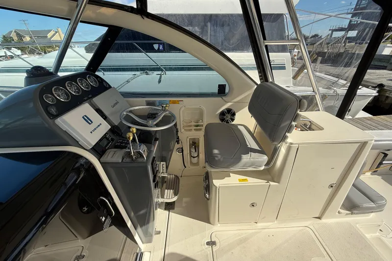 Slide: The Image of 2004 Pursuit 3100 Offshore boat cockpit with steering wheel and control panel. - 12