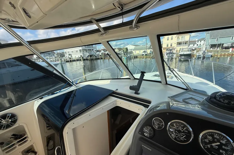 Slide: The Image of 2004 Pursuit 3100 Offshore boat interior with dashboard and marina view. - 15