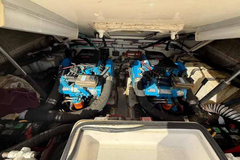 Slide: The Image of 2004 Pursuit 3100 Offshore engine compartment with twin blue marine engines. - 27