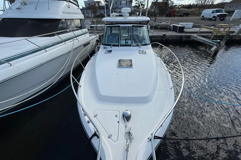 Slide: The Image of 2004 Pursuit 3100 Offshore boat docked at marina, top view. - 32