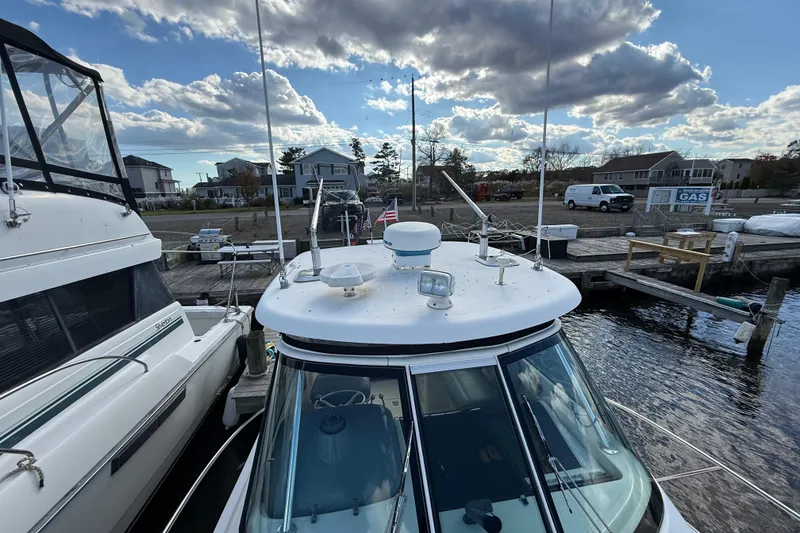 Slide: The Image of 2004 Pursuit 3100 Offshore boat docked at marina under cloudy sky. - 34