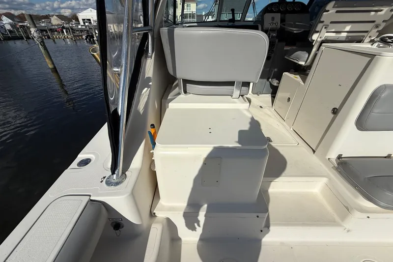 Slide: The Image of 2004 Pursuit 3100 Offshore boat interior with seating and storage compartments. - 35