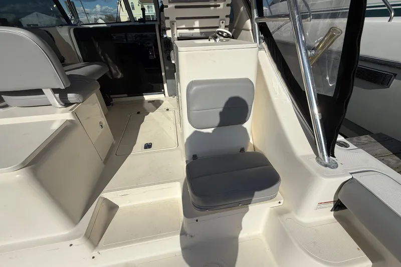 Slide: The Image of 2004 Pursuit 3100 Offshore boat interior with seating and storage compartments. - 37
