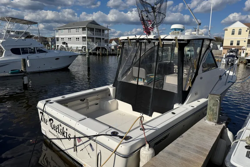 Slide: The Image of 2004 Pursuit 3100 Offshore boat docked at marina under a partly cloudy sky. - 4