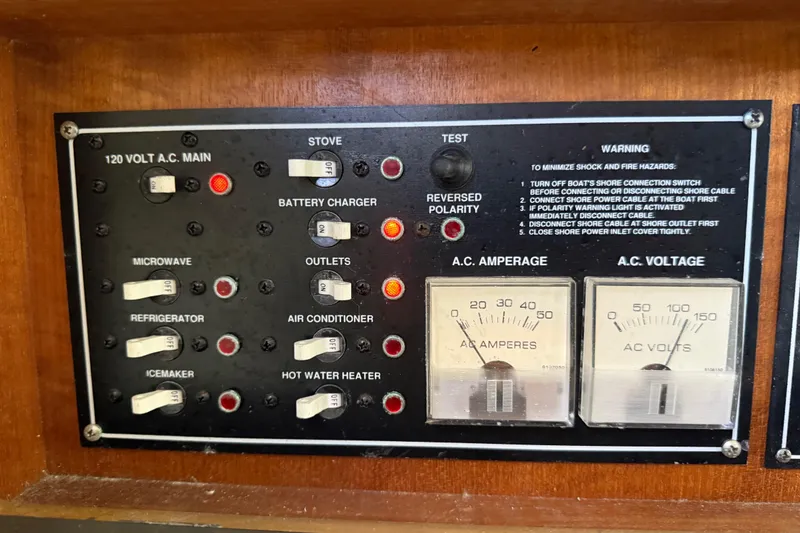 Slide: The Image of Electrical control panel on a 2004 Pursuit 3100 Offshore boat with various switches and gauges. - 42