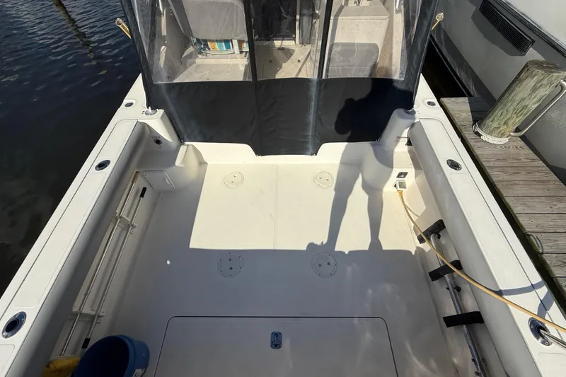 Slide: The Image of 2004 Pursuit 3100 Offshore boat deck with seating and dock view. - 6